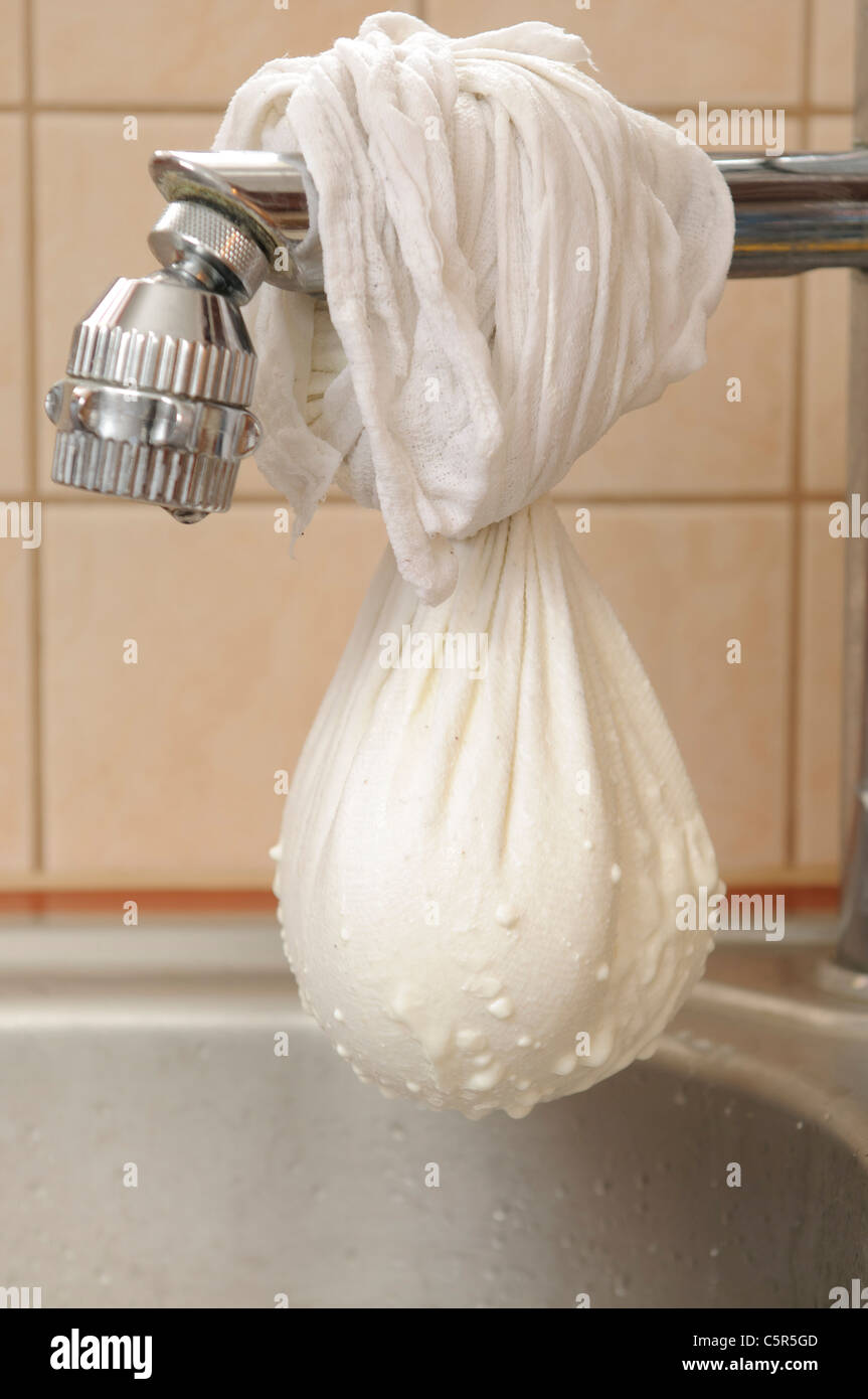 Yogurt appeso su di un rubinetto in cucina per poter essere spremuto adn essere più denso Foto Stock