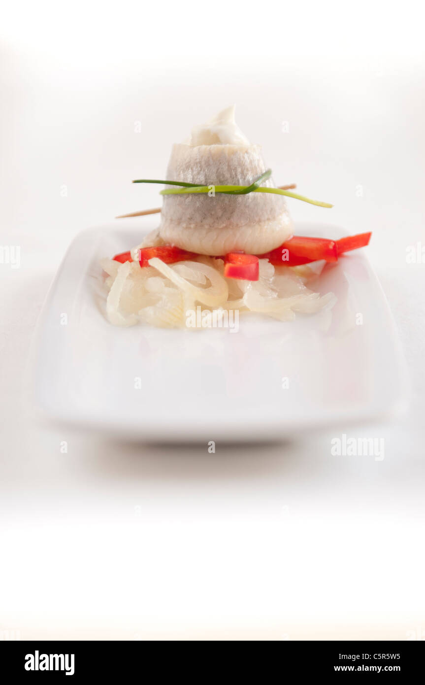 Le aringhe marinate filet con erba cipollina e cipolla sulla piastra bianca Foto Stock