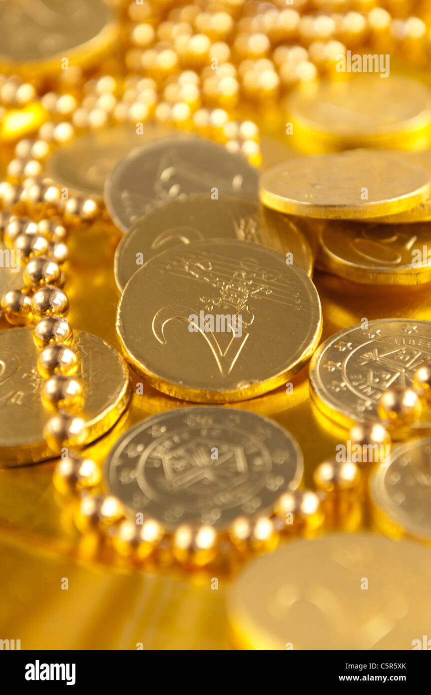 Golden cioccolato monete in euro sulla piastra di oro Foto Stock