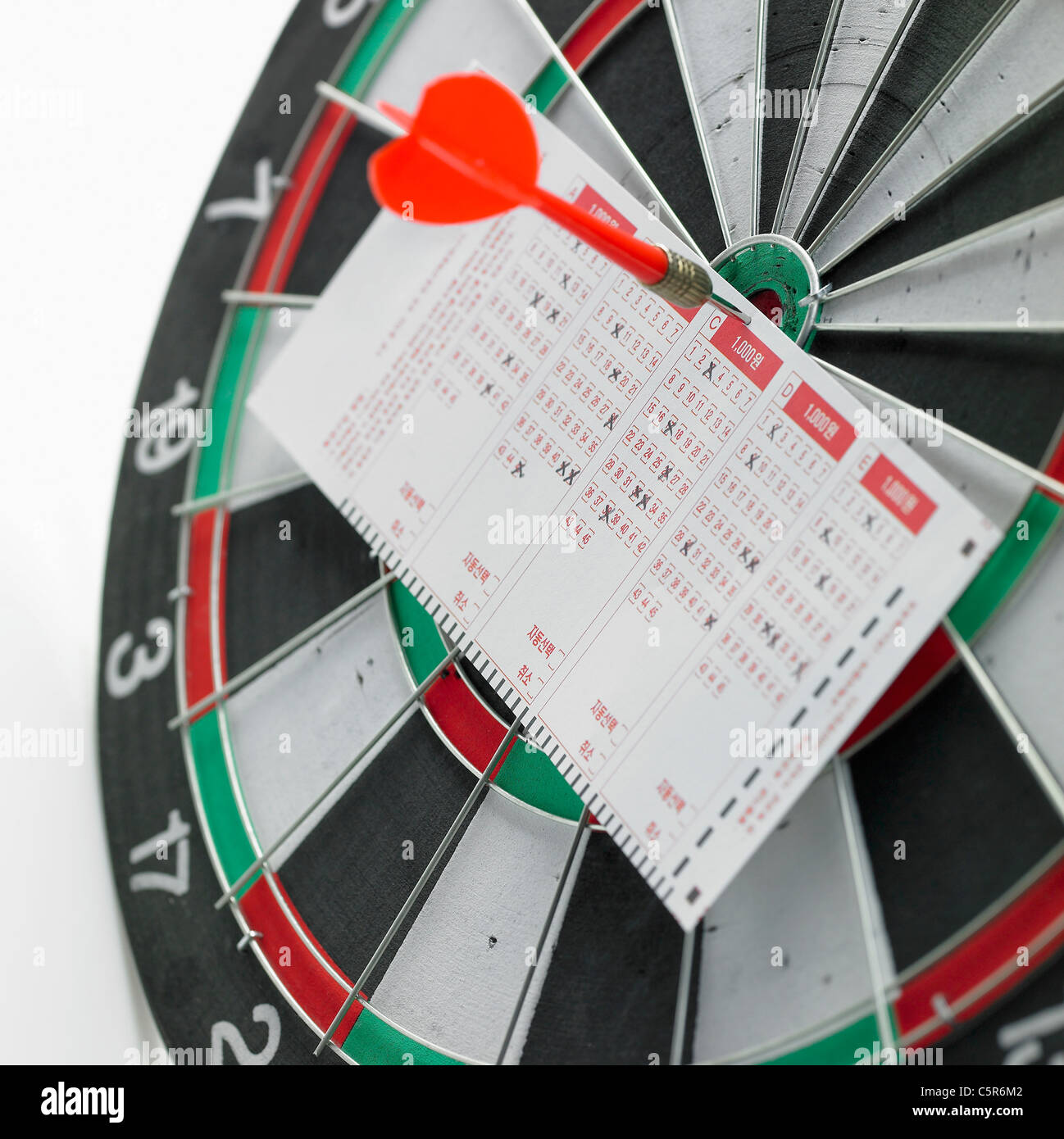 Biglietto della lotteria mettere su una scheda dart Foto Stock