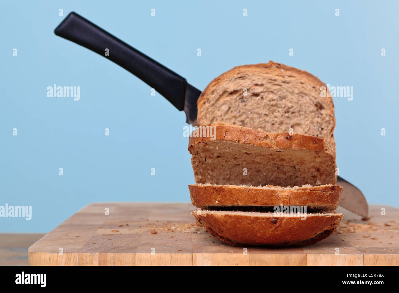 Foto di integrale di una pagnotta di pane tagliata con un coltello. Foto Stock