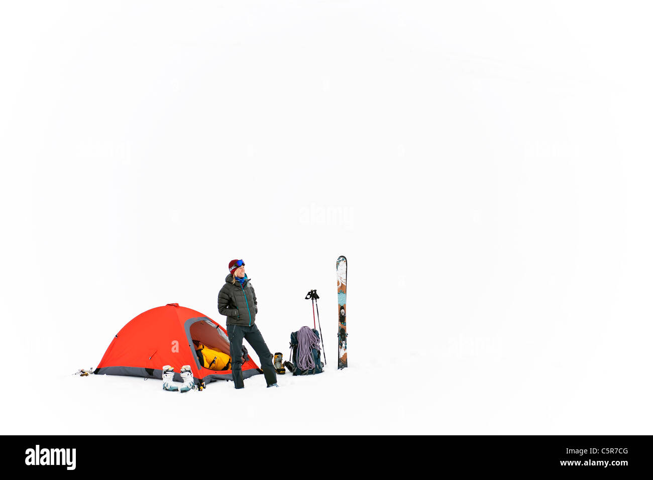 Un sorriso felice alpinista con tutte le sue attrezzature al campo base. Foto Stock