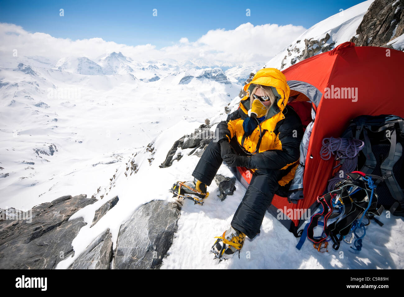 Un alpinista seduto in tenda con mascherina di ossigeno su molto ad alta altitudine. Foto Stock