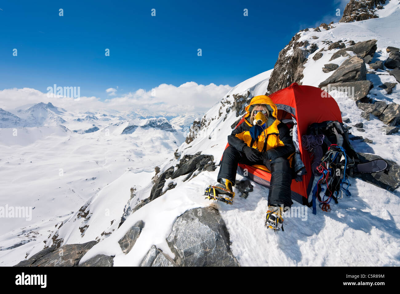Un scalatore in tenda molto ad alta altitudine con ossigeno apparato respiratorio. Foto Stock