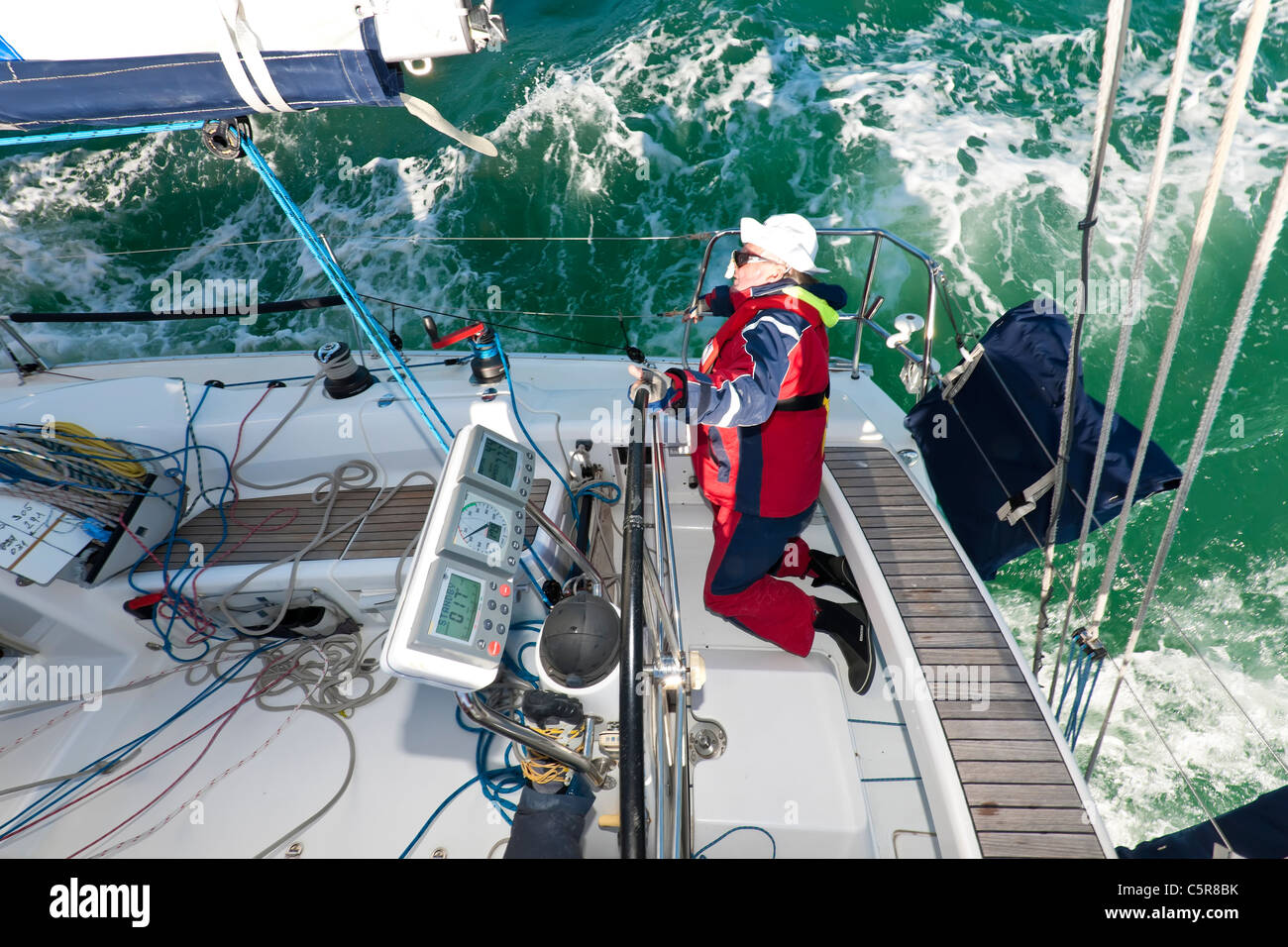 Il capitano lo sterzo di un oceano andando yacht in gara su instabili onde dell'oceano. Foto Stock