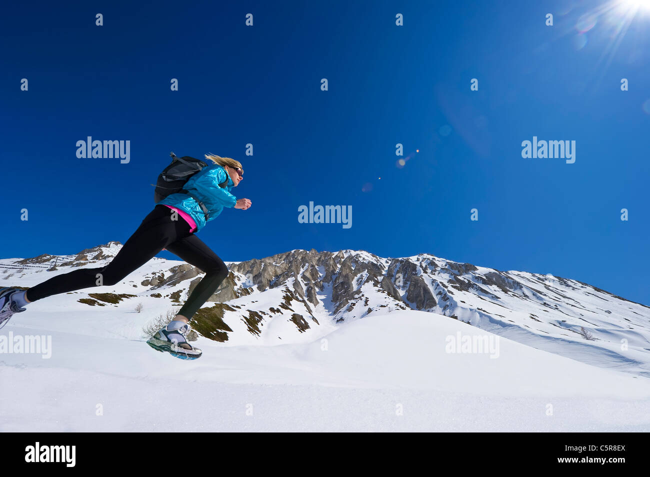 Esecuzione del pareggiatore attraverso le montagne nevose Foto Stock