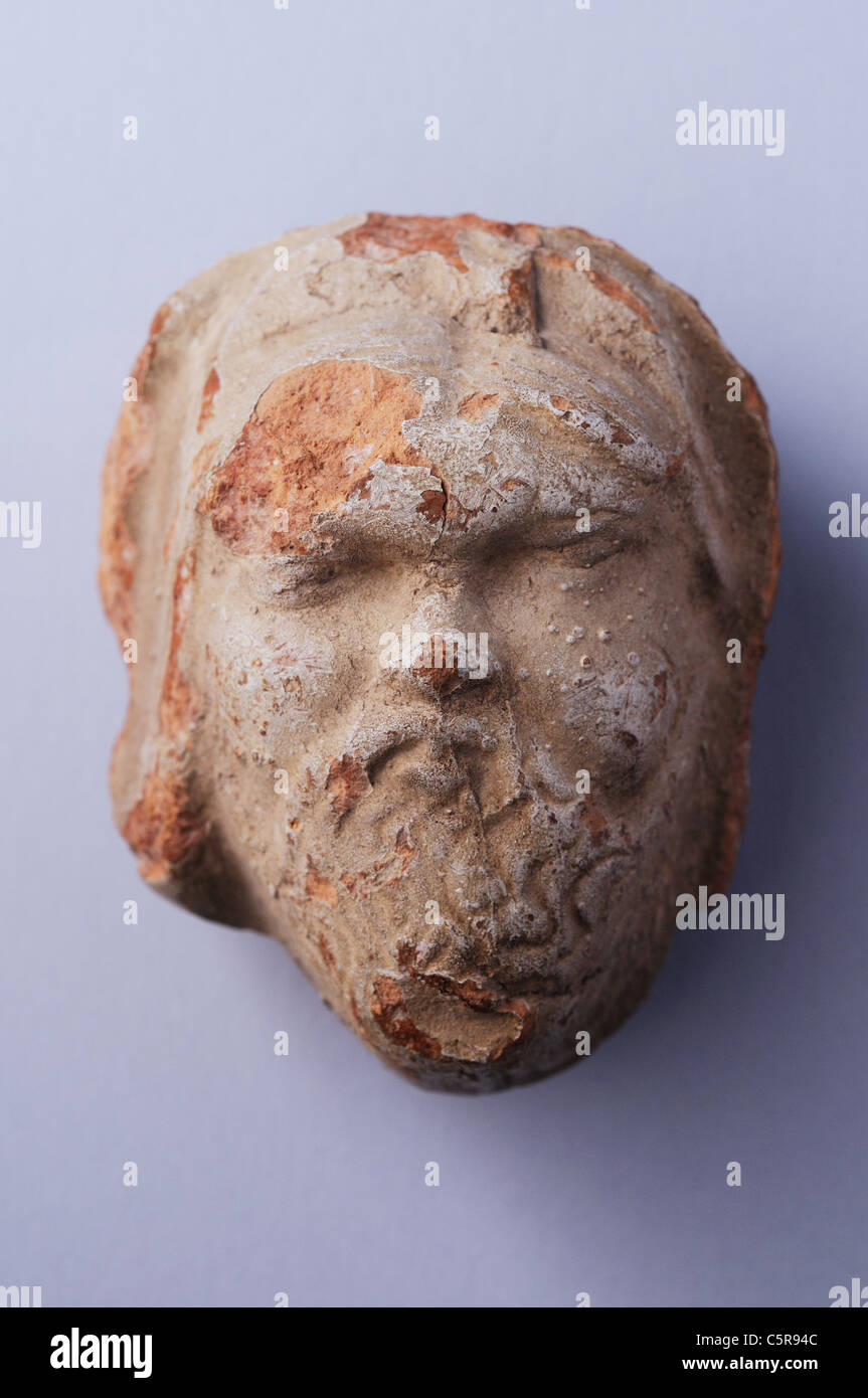 Antefisse in terracotta che rappresenta un barbuto testa con slittamento chiaro . Periodo romano in Complutum . Spagna Foto Stock