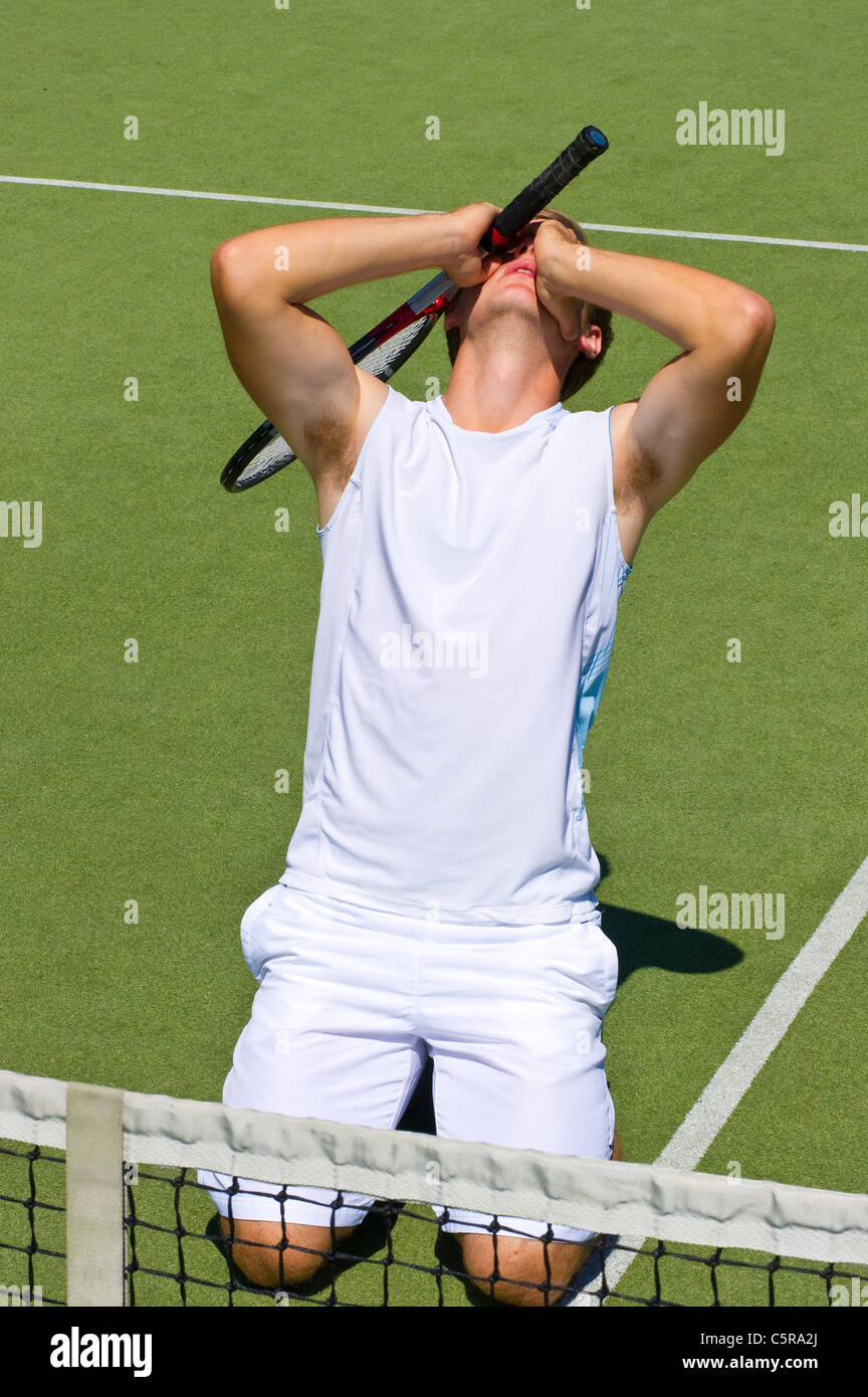 Un giocatore di tennis scende dopo aver perso la partita. Foto Stock