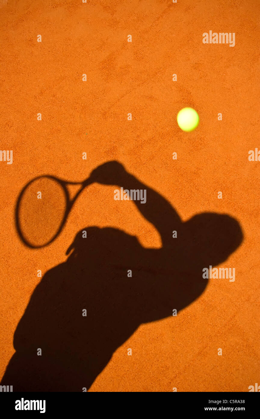 La silhouette di un giocatore di tennis di servire. Foto Stock