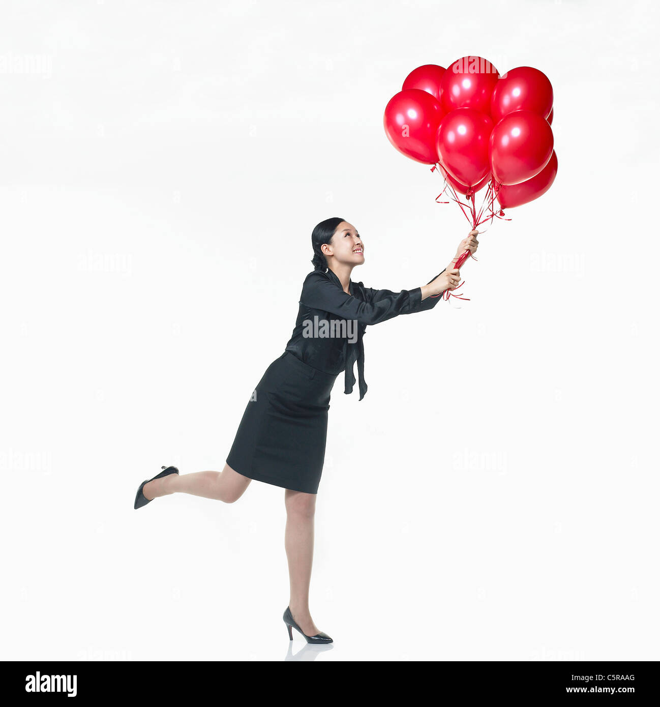 Una donna azienda palloncini rossi Foto Stock