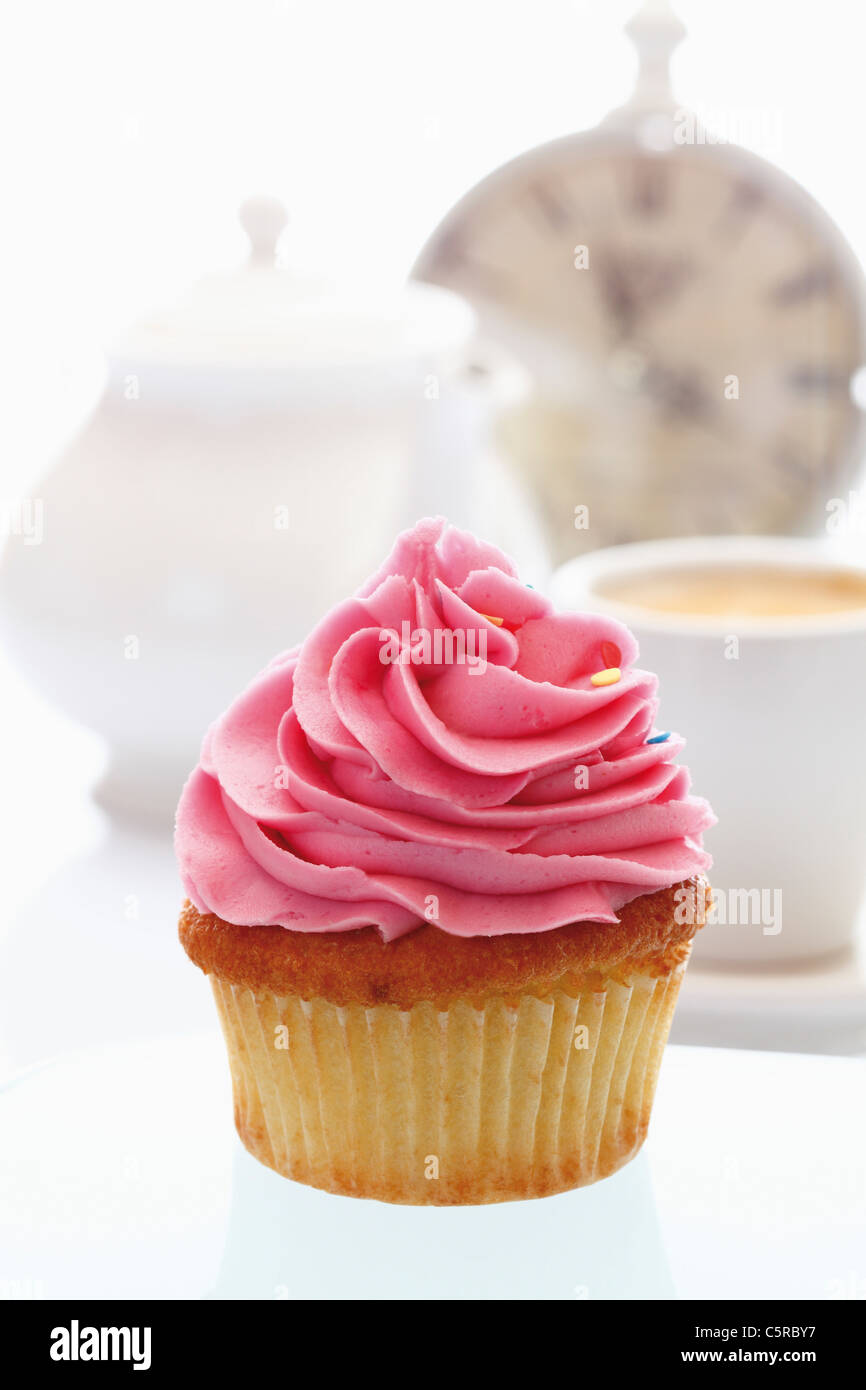 Close up di fragola crema di burro cupcake contro uno sfondo bianco Foto Stock
