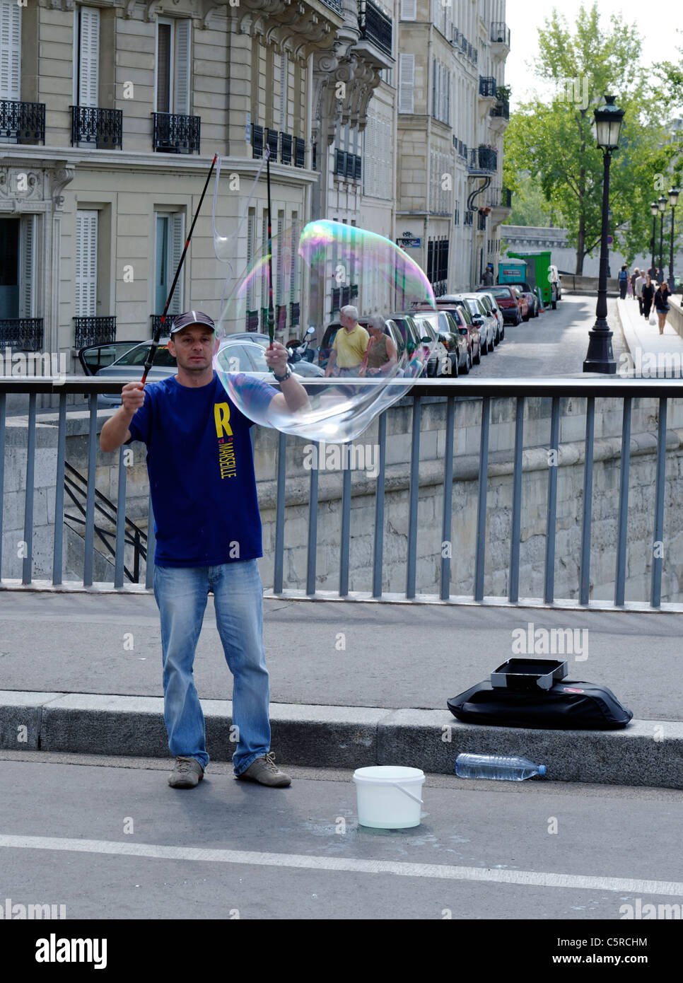 Animatore di strada a soffiare bolle di liquido e con un cerchio a Parigi, Francia Foto Stock
