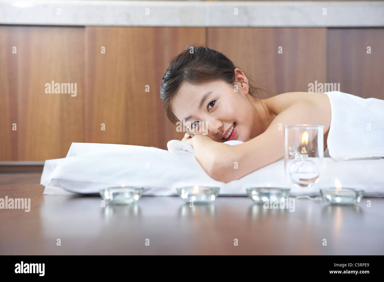 Una donna sdraiata con candele Foto Stock