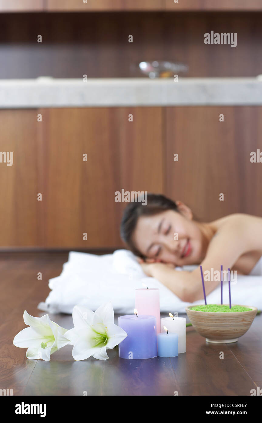 Una donna sdraiata con candele Foto Stock