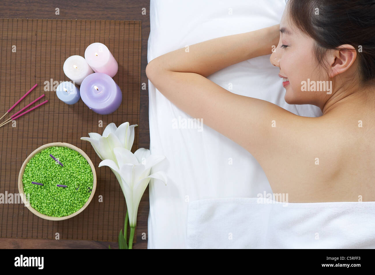 Una donna sdraiata con candele Foto Stock