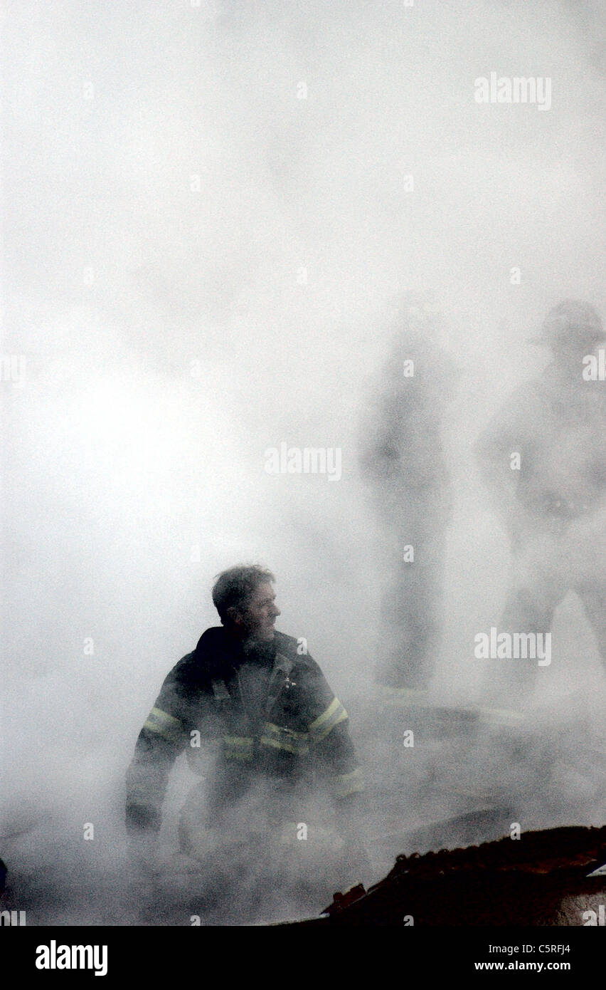Fireman passeggiate attraverso il fumo a ground zero, World Trade Center seguenti 911 attacchi terroristici Foto Stock