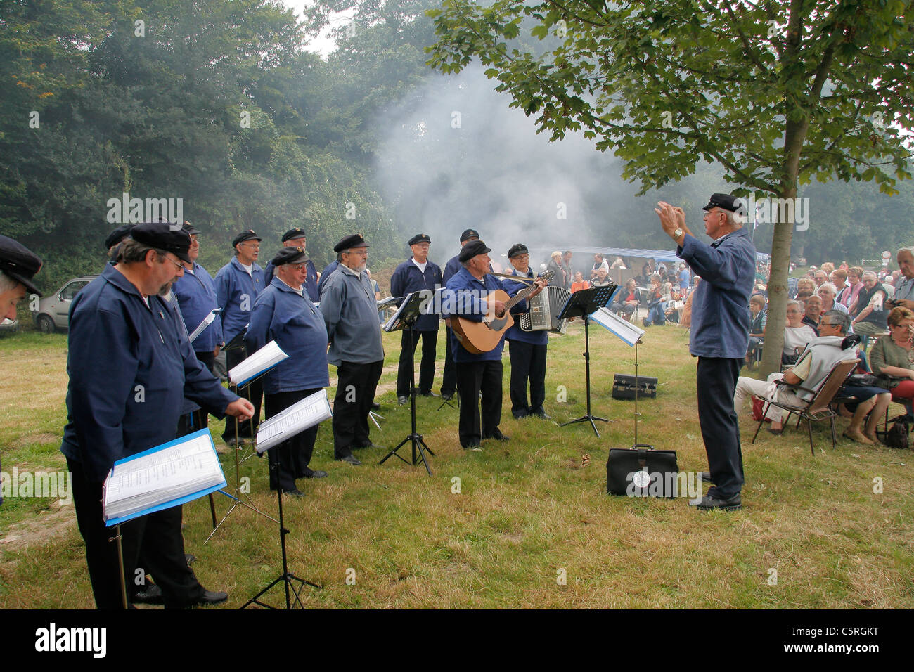 Un gruppo di cantanti (sea shanties) all'aperto circondato dal pubblico (mare evento : la Route du cidre). Brittany, Francia. Foto Stock