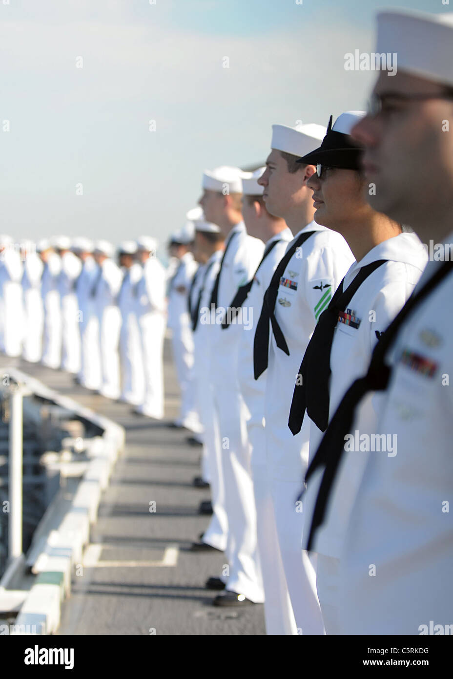 I marinai uomo le rotaie sul ponte di volo della portaerei USS Abraham Lincoln (CVN 72) come la nave tira in Los Angeles Foto Stock