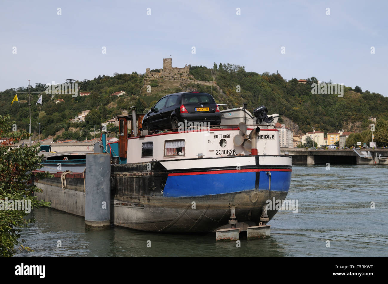 Grande Fiume chiatta per crociere sul Rodano a Vienne Francia con castello Chateau de la Batie sul Mont Salomon in background Foto Stock