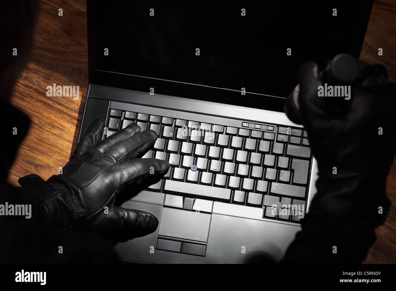 Uomo di rubare i dati da un computer portatile Foto Stock