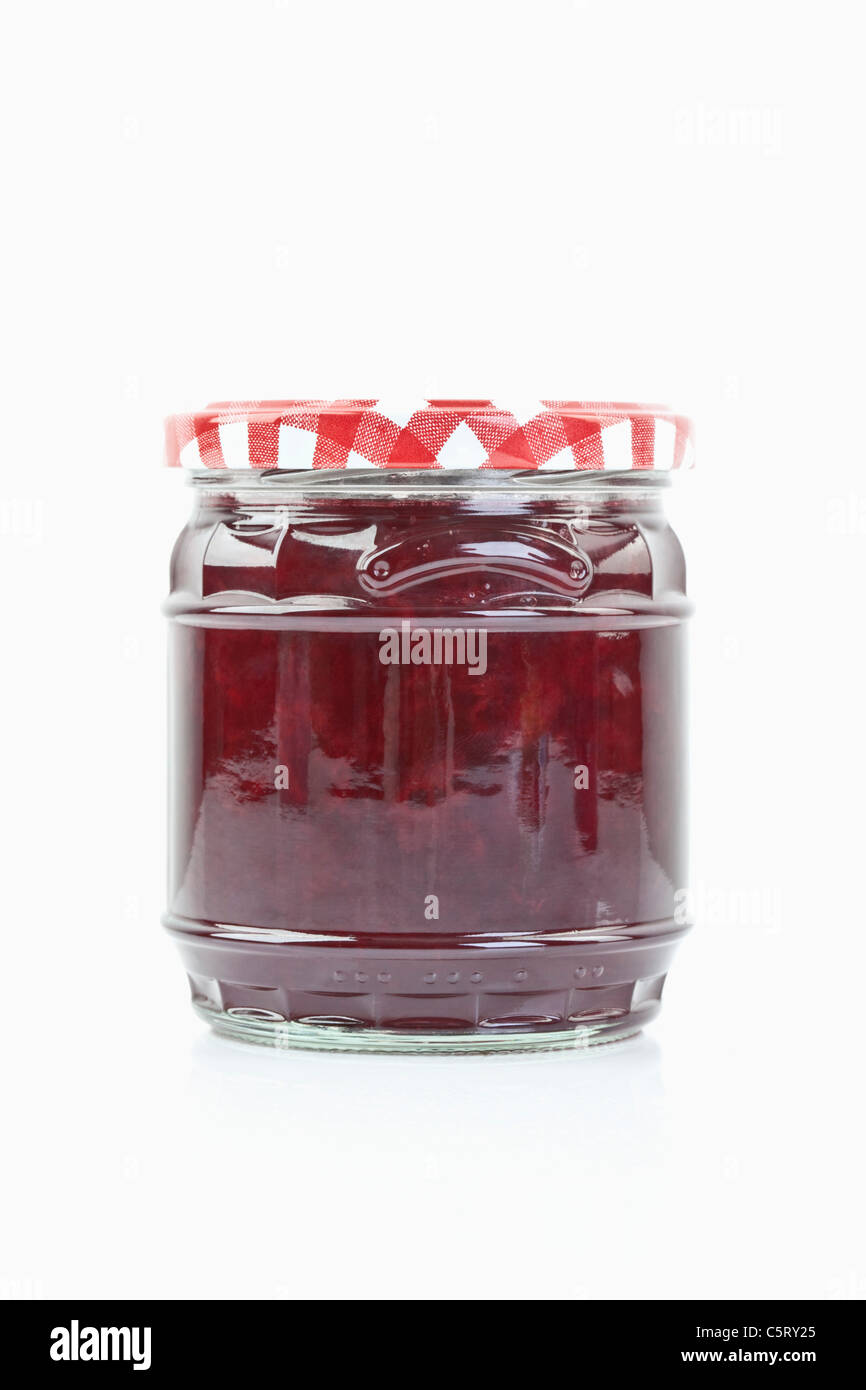 Il vasetto di vetro di marmellata di ciliege su sfondo bianco, close up Foto Stock