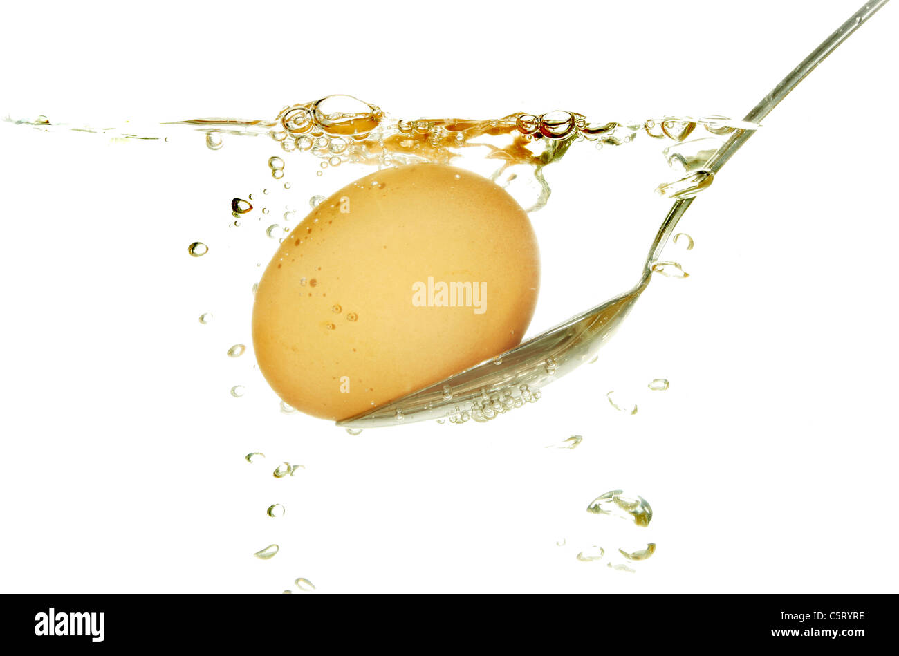 Uovo su un cucchiaio da cottura in acqua bollente Foto Stock