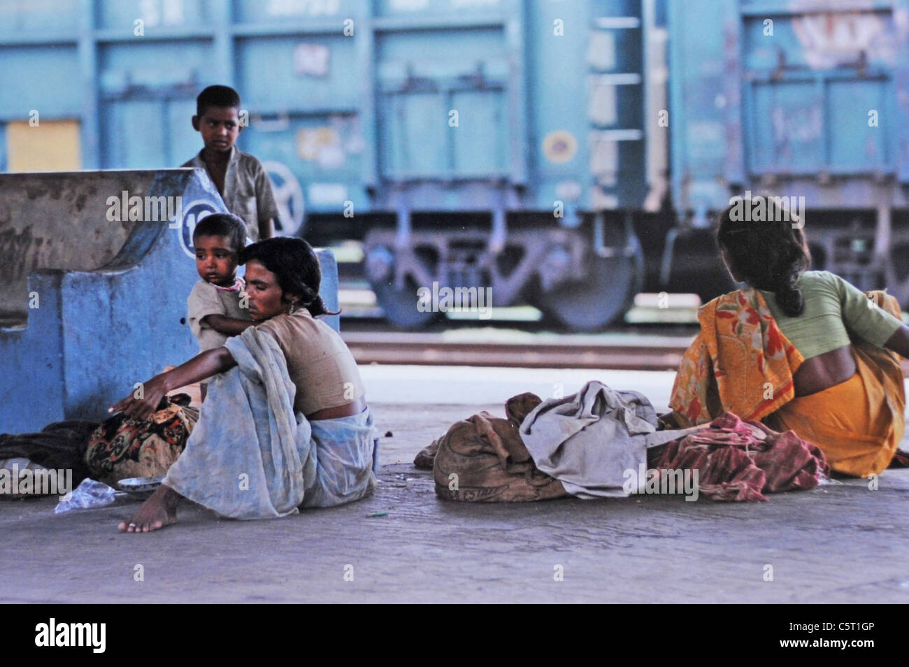 Famiglie di donne e bambini che vivono su piattaforme ferroviarie e piste in Delhi India Foto Stock
