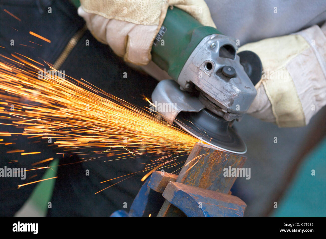 Close up uomo affilatura di pezzo di ferro con la smerigliatrice angolare  Foto stock - Alamy