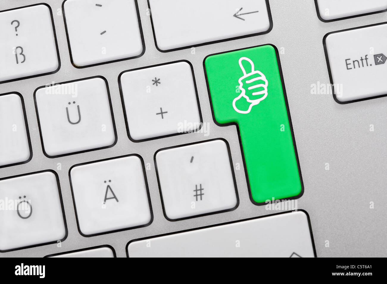 Close up di chiavi di computer con il pollice in alto simbolo sul tasto verde Foto Stock