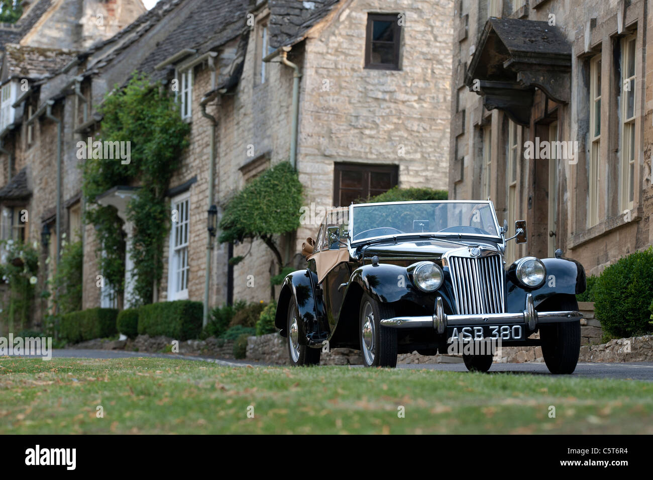 Annata 1955 MG TF 1500 auto parcheggiate al di fuori di case nella città medievale di Burford . Cotswolds, Inghilterra Foto Stock