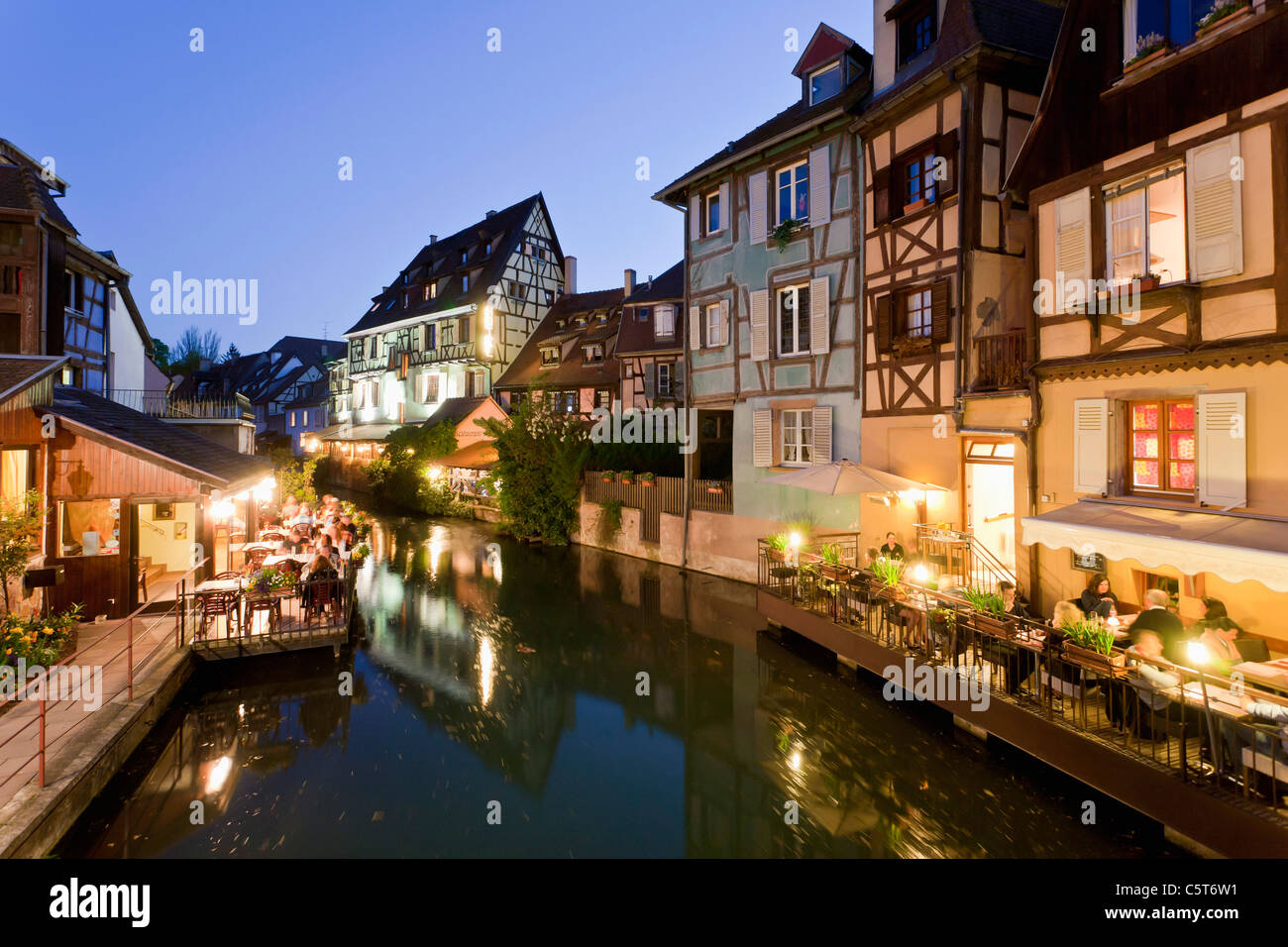 Francia, Alsazia, Colmar, Krutenau, vista la Petite Venise quarti con ristorante vicino al fiume Lauch di notte Foto Stock