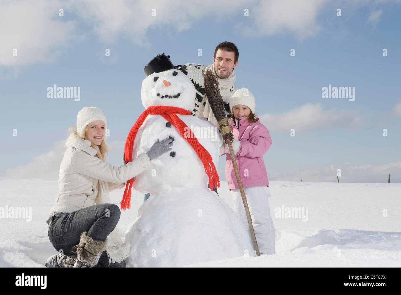 In Germania, in Baviera, Monaco di Baviera, Famiglia facendo un pupazzo di neve, ritratto Foto Stock