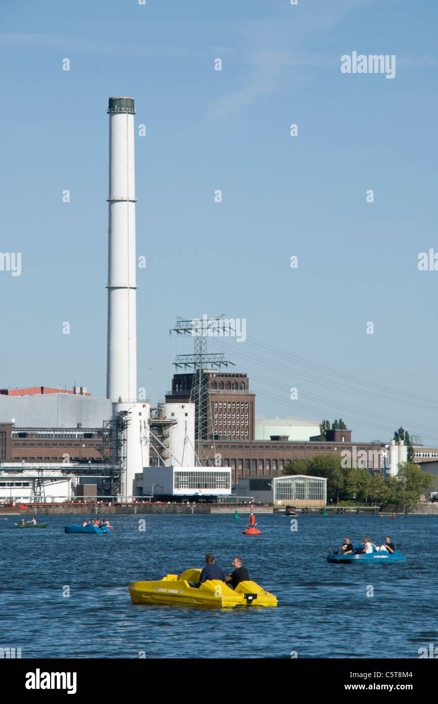 Germania, Berlino, pedalò sul fiume Spree, Power Station in background Foto Stock