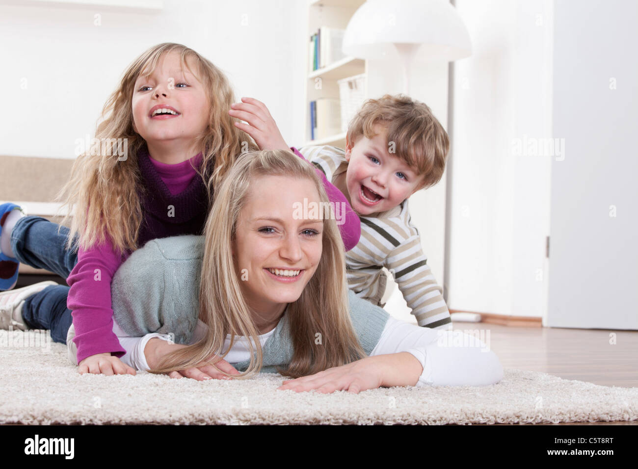 In Germania, in Baviera, Monaco di Baviera, figlia della madre e figlio giacente sul piano a casa Foto Stock
