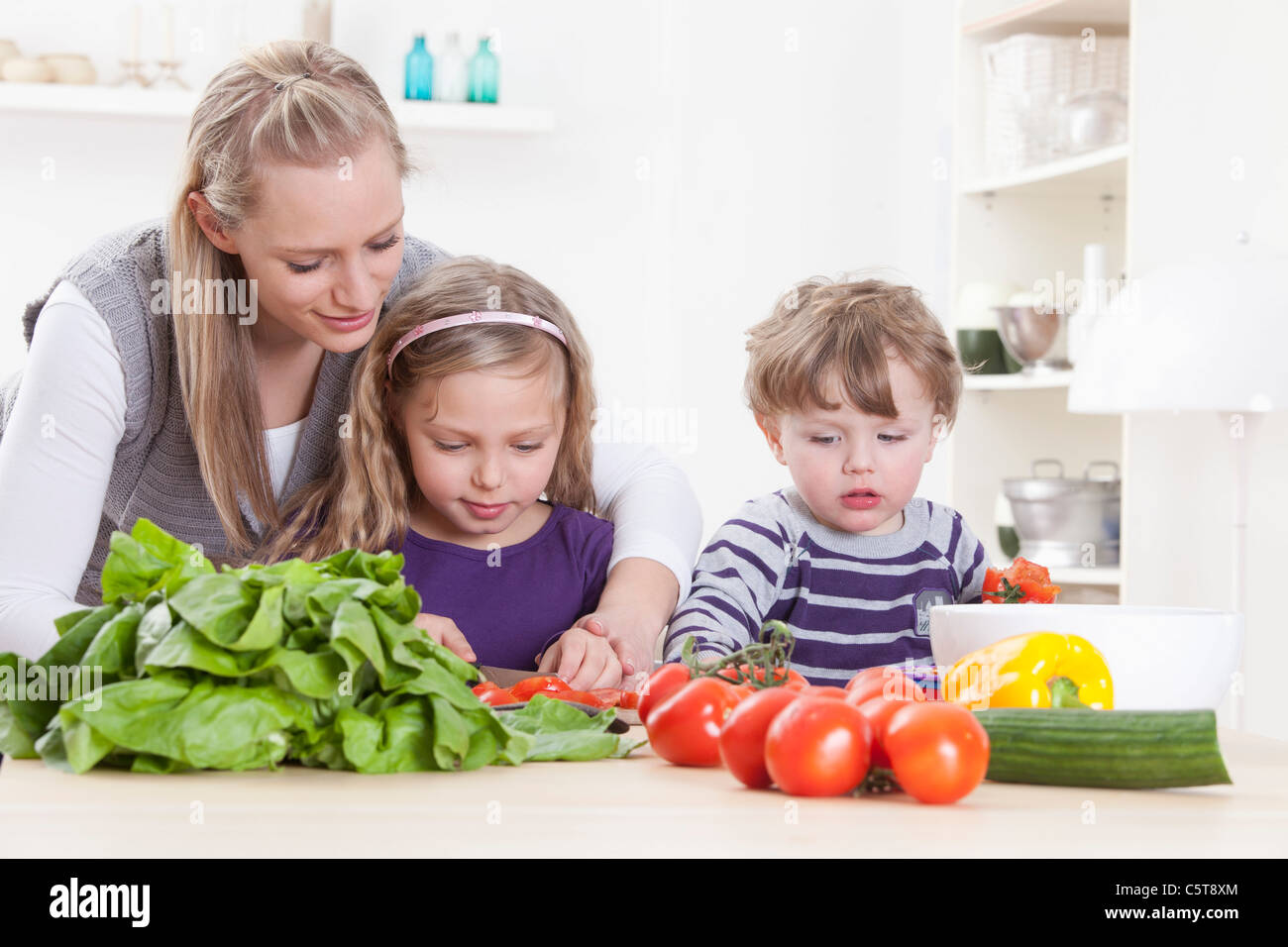 In Germania, in Baviera, Monaco di Baviera, figlia della madre e figlio la preparazione di insalata Foto Stock