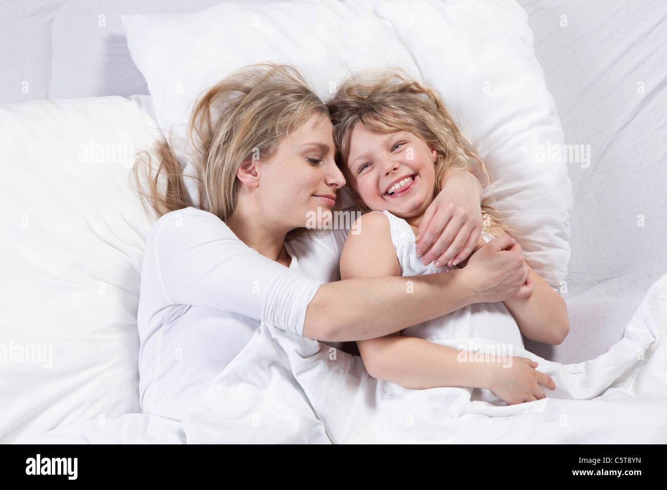 In Germania, in Baviera, Monaco di Baviera, madre e figlia giacente sul letto Foto Stock