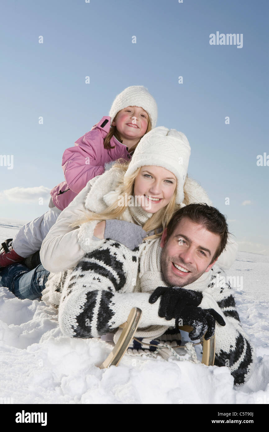 In Germania, in Baviera, Monaco di Baviera, Famiglia giacente sulla slitta, sorridente, ritratto Foto Stock
