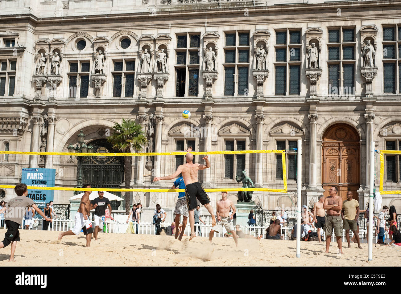 Persone a giocare a beach volley su un campo artificiale di fronte al Palazzo del Municipio durante il Paris Plage evento, Paris, Francia. Foto Stock