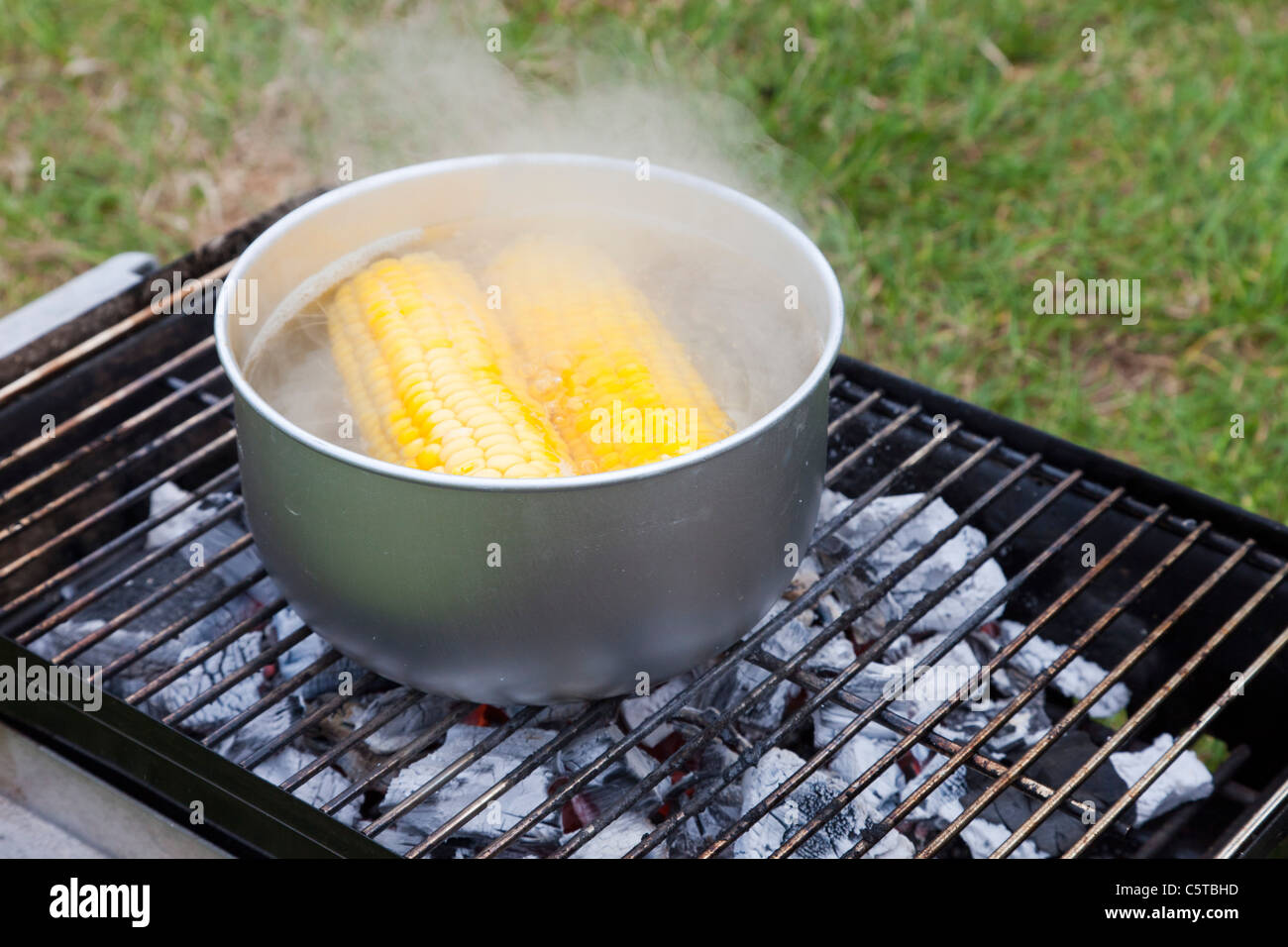 La cottura sulla pannocchia di mais su un barbecue Foto Stock
