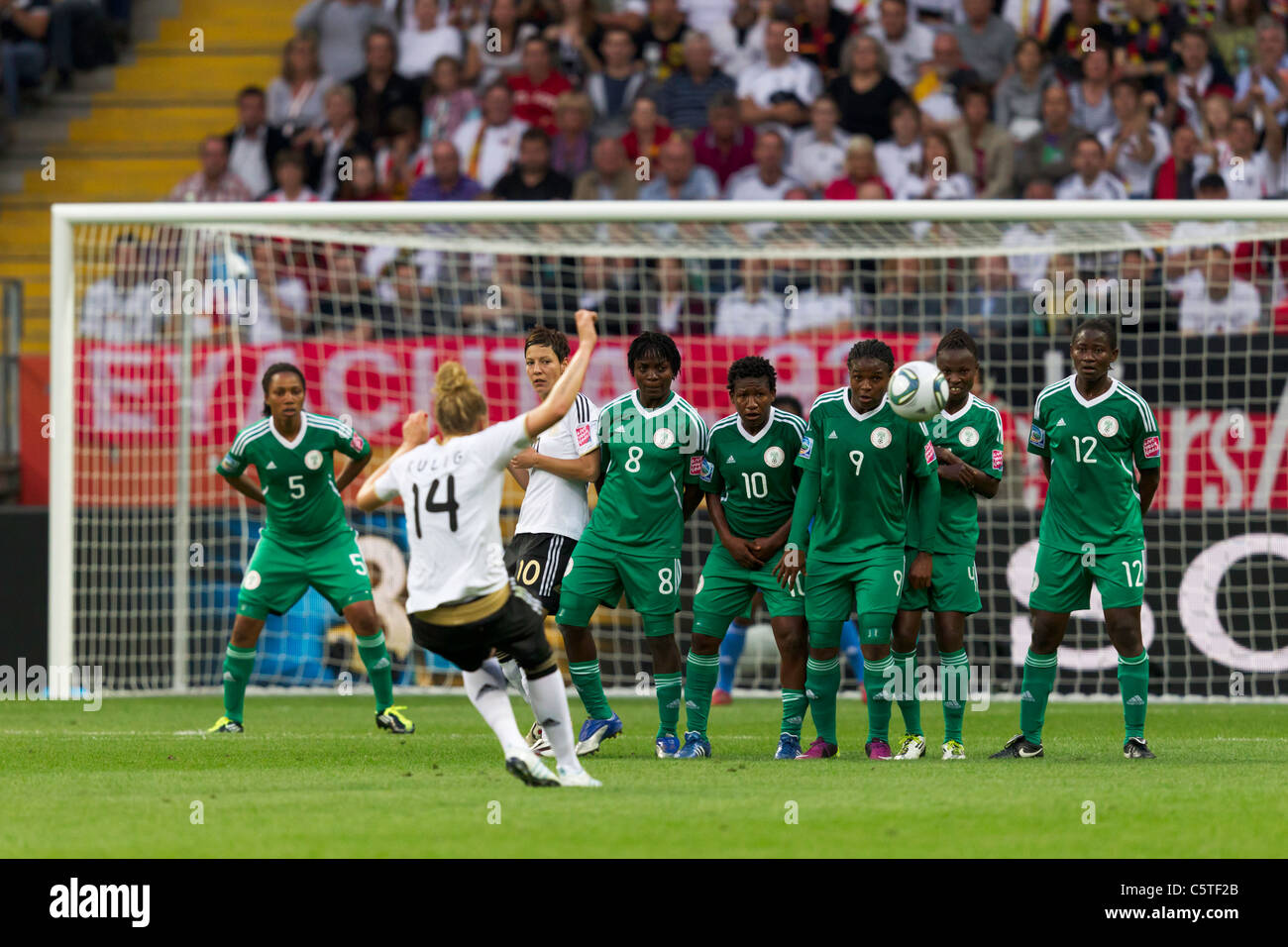 Kim Kulig della Germania (14) prende un calcio di punizione contro un nigeriano muraglia difensiva durante un 2011 FIFA Coppa del Mondo Donne partita di calcio. Foto Stock