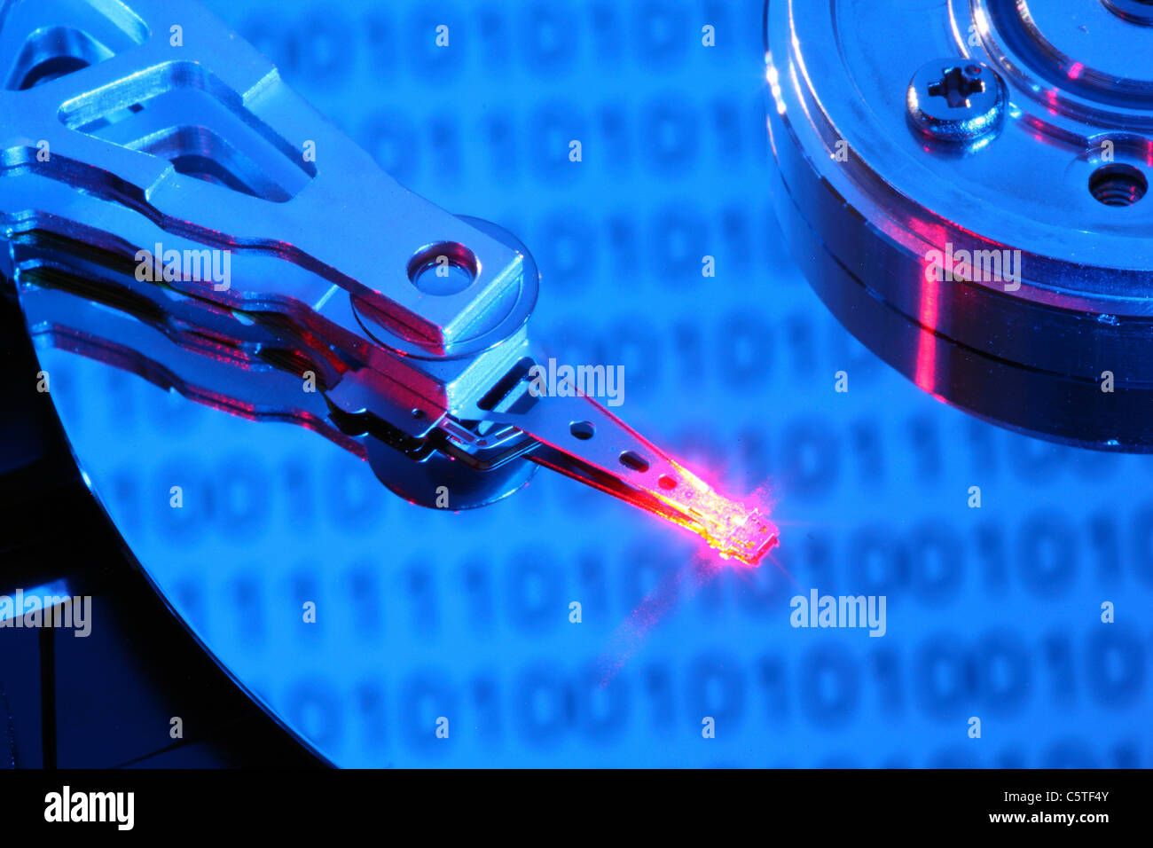 Unità disco rigido del computer, aperto, scrittura/lettura di testa e disco rigido. Codice binario i numeri sono riflettendo sul disco rigido. Simbolo. Foto Stock