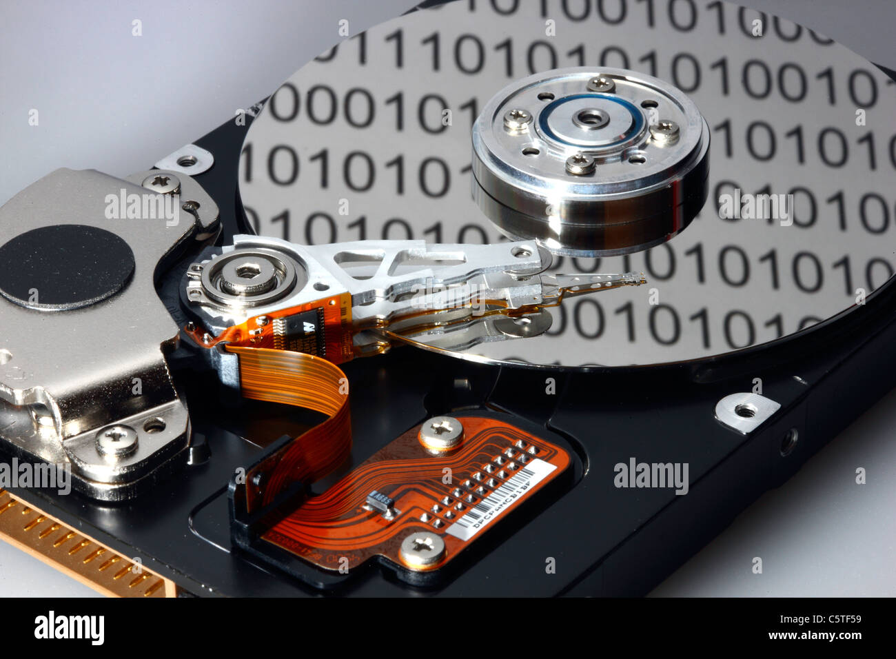 Unità disco rigido del computer, aperto, scrittura/lettura di testa e disco rigido. Codice binario i numeri sono riflettendo sul disco rigido. Simbolo. Foto Stock