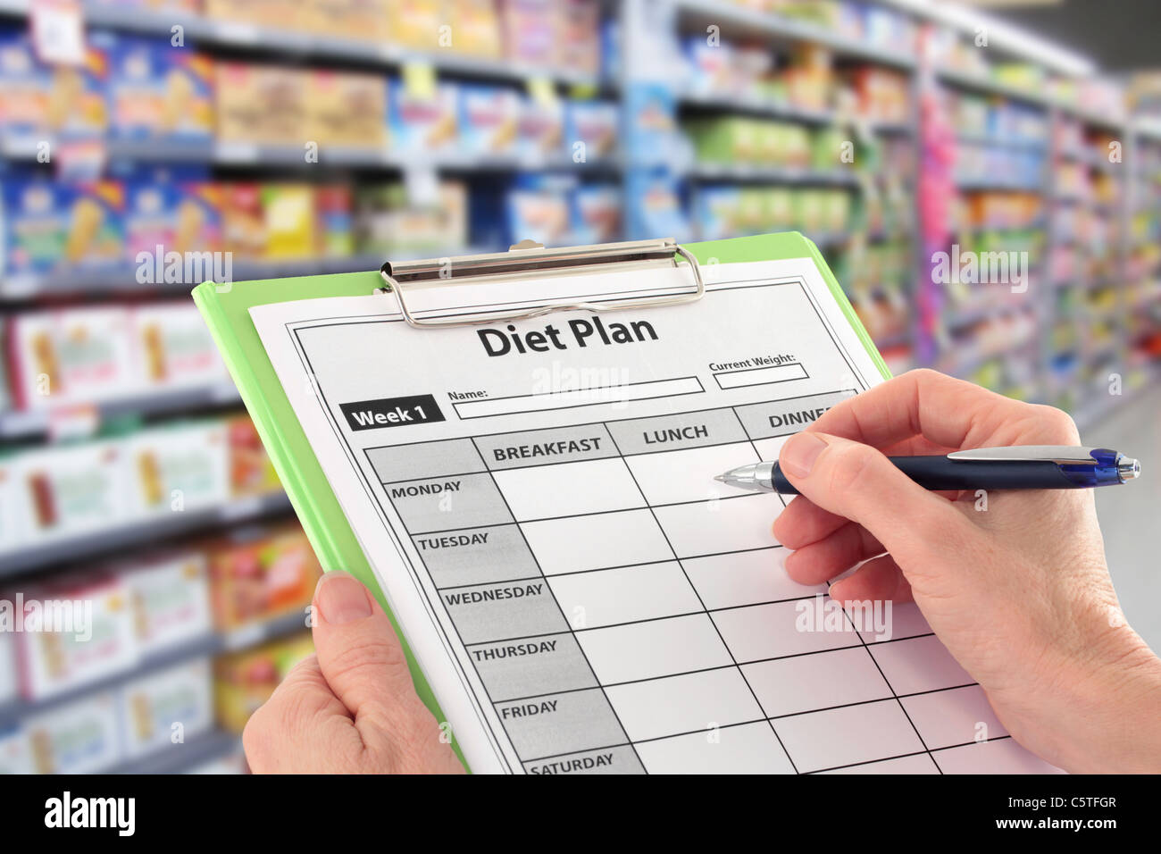 La scrittura di un programma di dieta nel supermercato Foto Stock