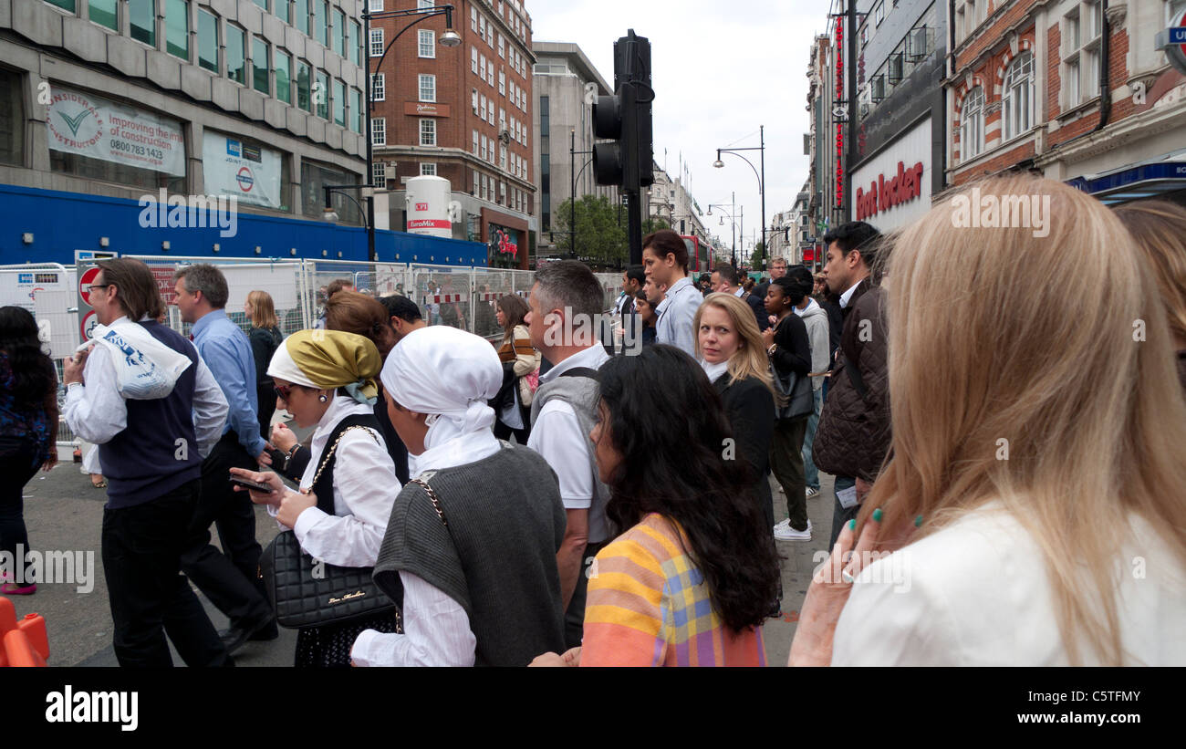 Un gruppo di acquirenti attraversando Oxford Street vicino a lavori stradali alla stazione della metropolitana di Bond Street a Londra England Regno Unito KATHY DEWITT Foto Stock