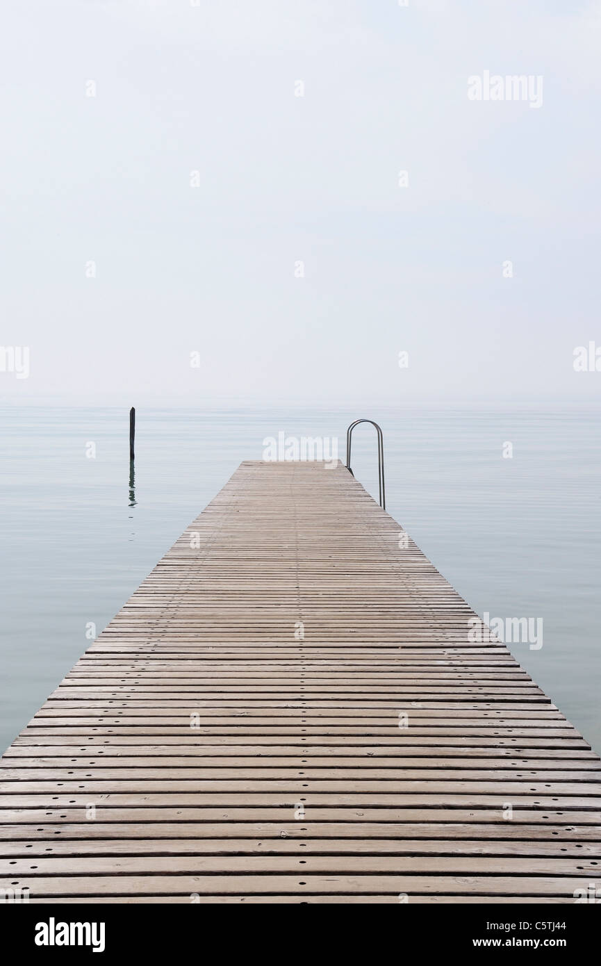 L'Italia, pontile sul Lago di Garda con nebbia Foto Stock