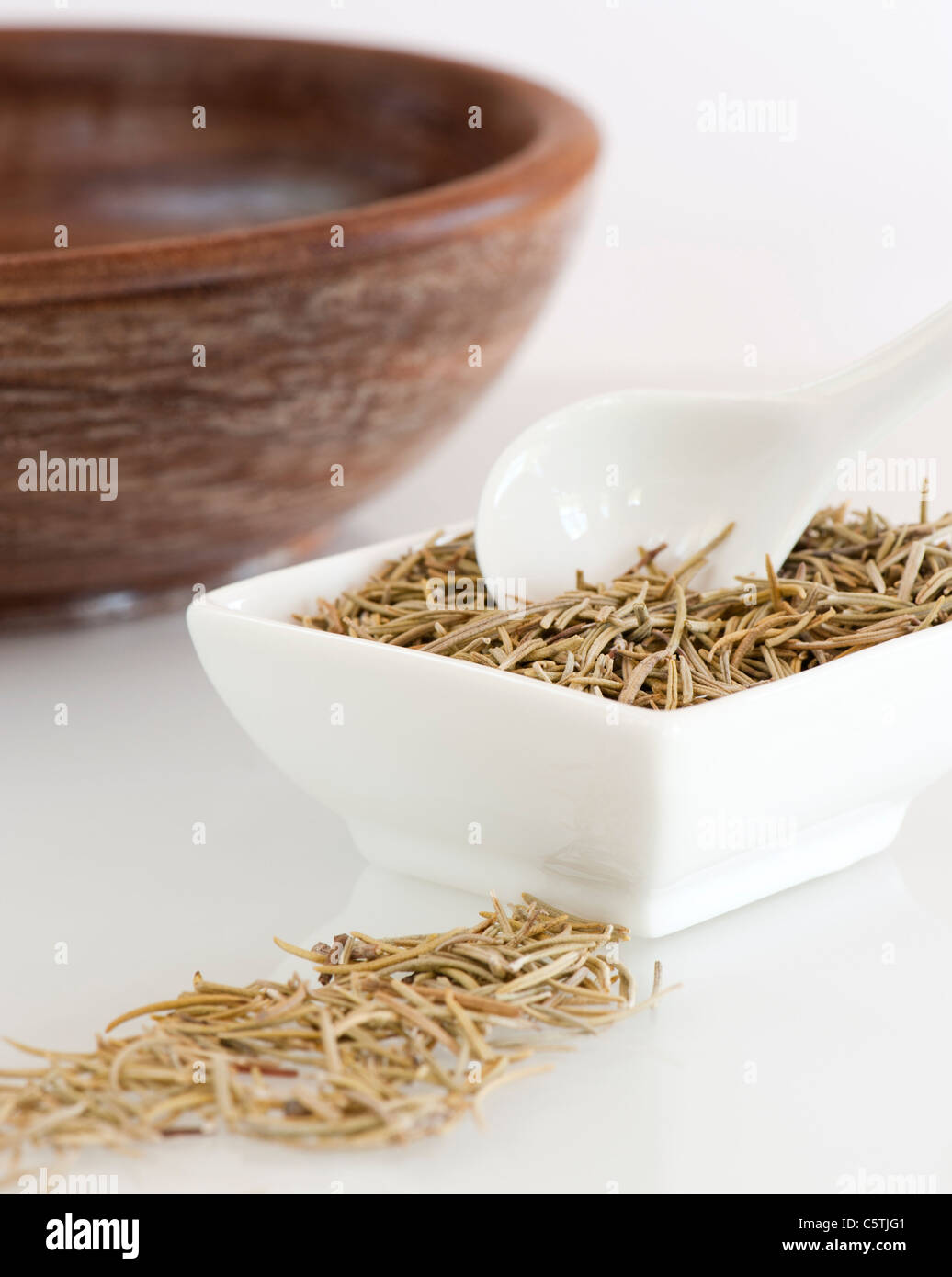 Un piatto pieno di erba aromatica, rosmarino essiccato Foto Stock