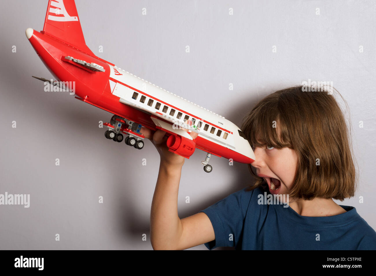 Ragazza giovane (tomboy) giocando con un modello di Lego aereo jet