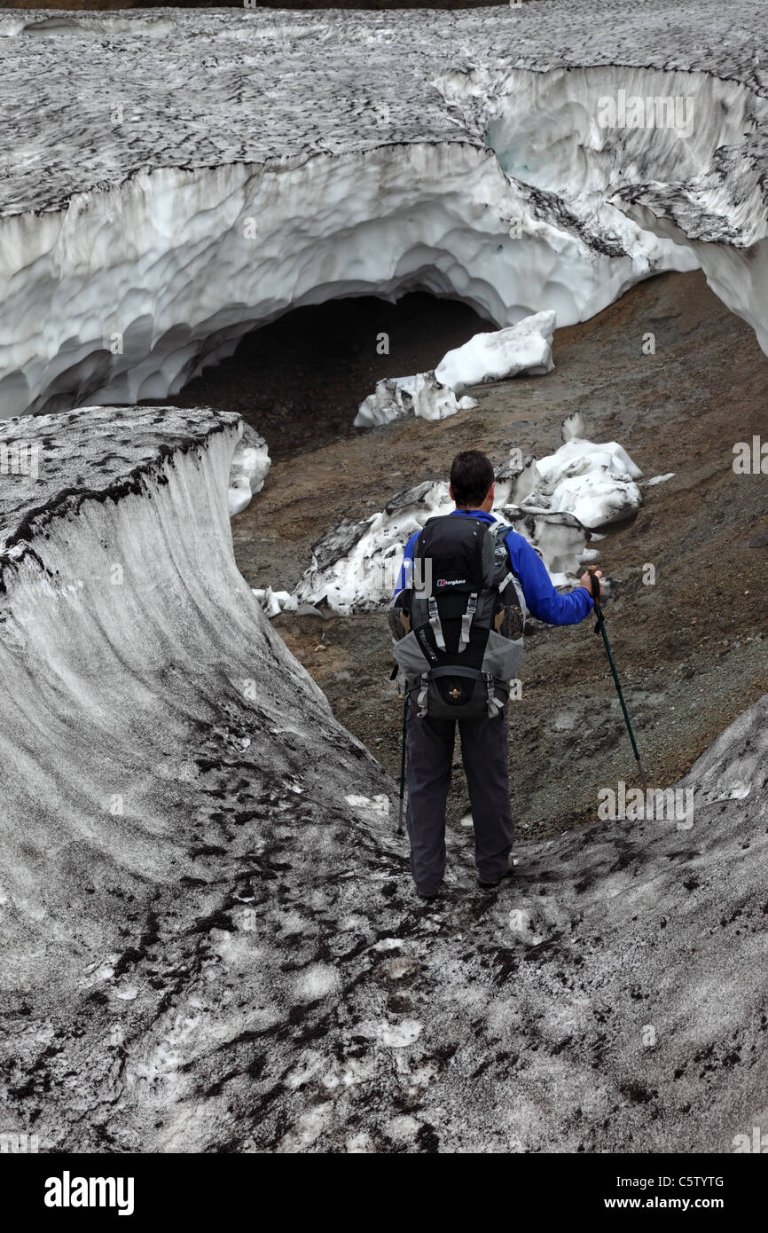 Trekker in modo sicuro ad esplorare una forma ripiegata la grotta di ghiaccio sul Laugavegur (Laugavegurinn) Sentiero escursionistico Islanda Foto Stock