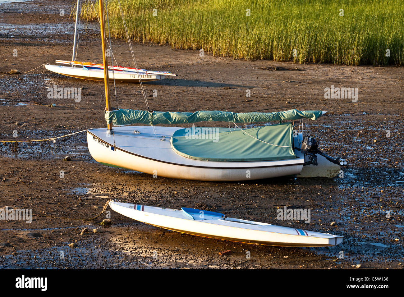 Tre piccole barche a vela alto e asciutto a Porto Pamet al tramonto Foto Stock