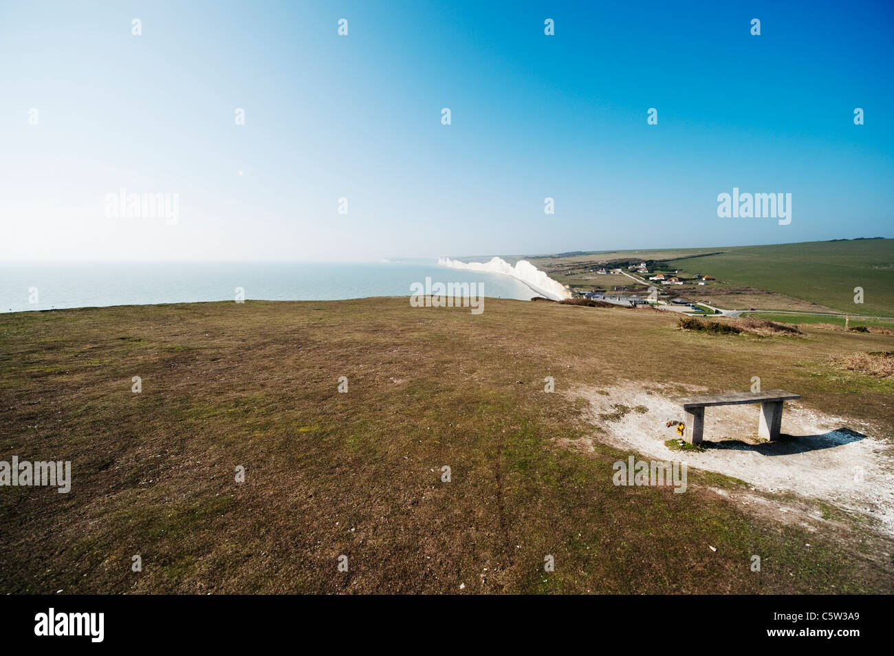 Panca in legno sedile con fiori che si affaccia sul Canale della Manica a Beachy Head Foto Stock